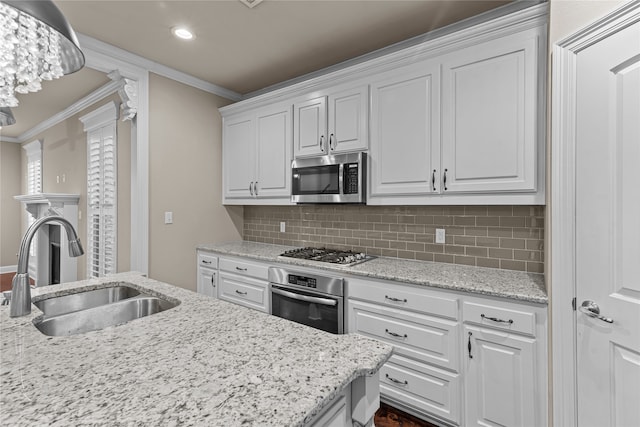 kitchen with crown molding, white cabinetry, sink, and appliances with stainless steel finishes