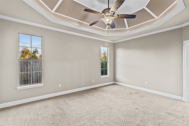 carpeted spare room featuring a tray ceiling, crown molding, and ceiling fan