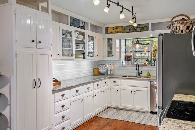 kitchen with white cabinetry, sink, light stone counters, and light hardwood / wood-style floors