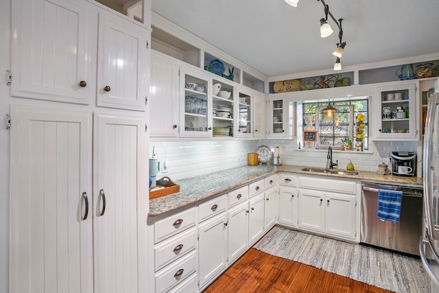 kitchen featuring dishwasher, sink, light stone counters, white cabinets, and hardwood / wood-style flooring