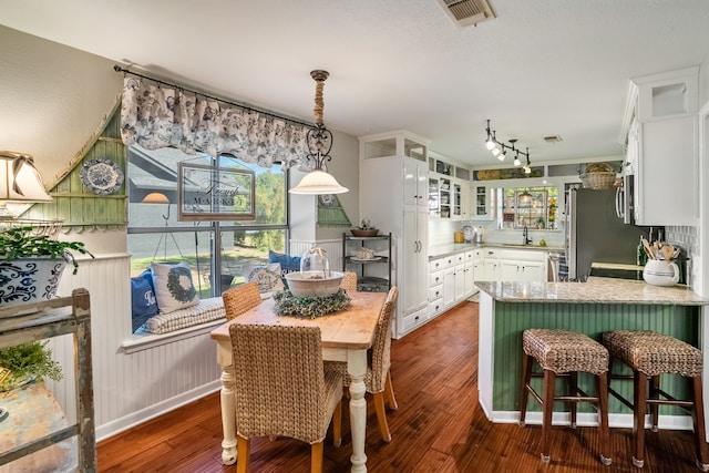 kitchen featuring backsplash, white cabinetry, dark wood-type flooring, and stainless steel appliances