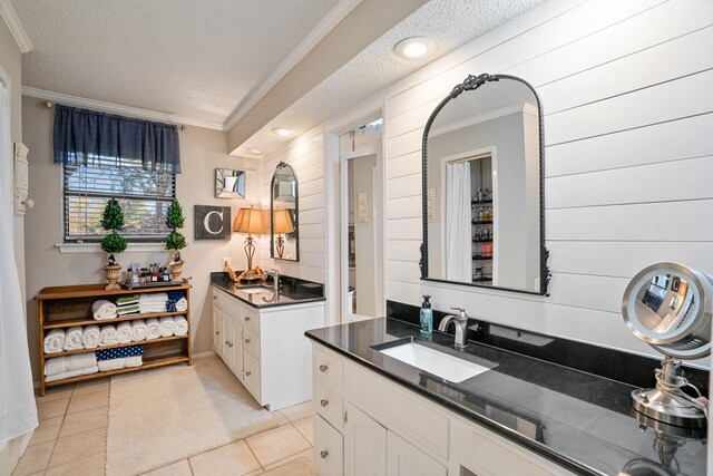 bathroom featuring tile patterned flooring, vanity, a textured ceiling, and ornamental molding