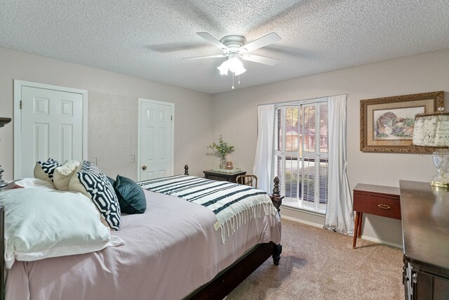 bedroom with ceiling fan, light colored carpet, and a textured ceiling