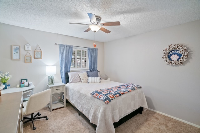 bedroom with a textured ceiling, light colored carpet, and ceiling fan