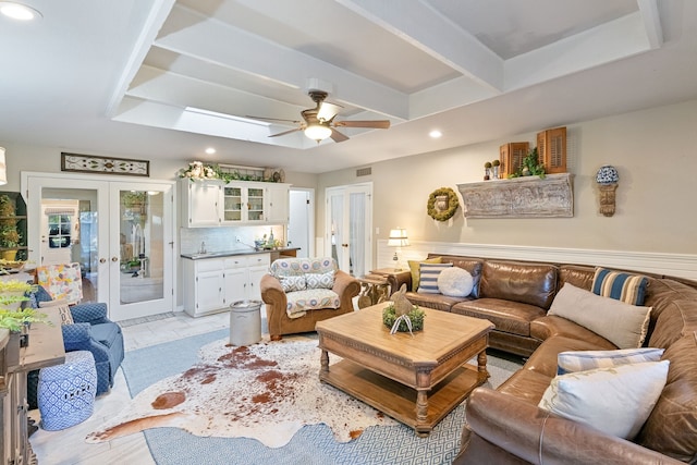 living room with french doors, a skylight, ceiling fan, and sink