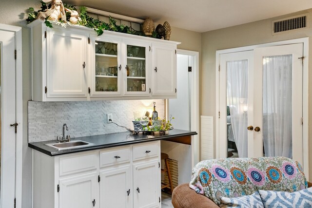 kitchen featuring backsplash, sink, and white cabinets