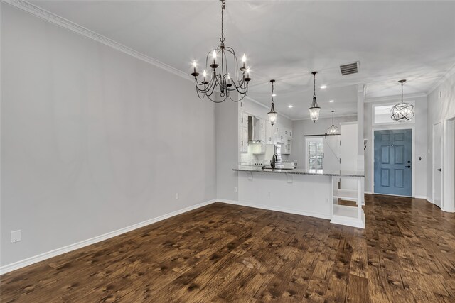 kitchen with pendant lighting, white cabinets, kitchen peninsula, and crown molding