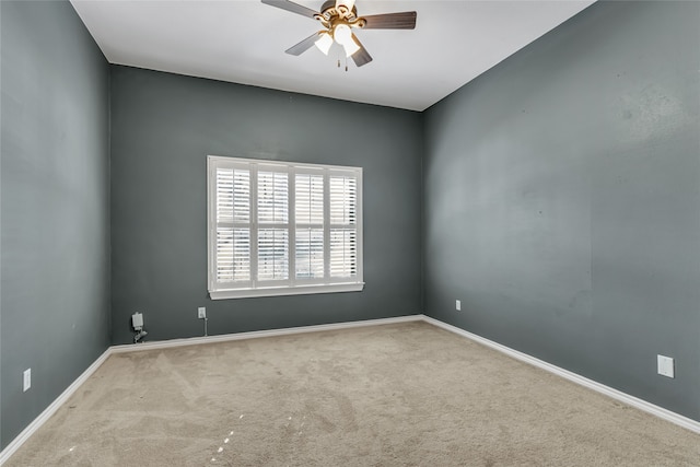 spare room with ceiling fan and light colored carpet