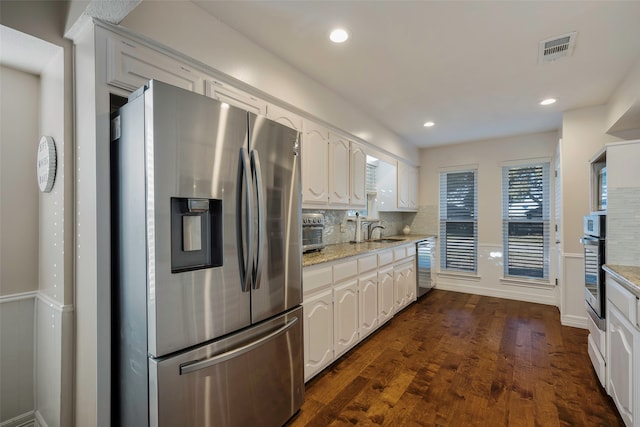 kitchen featuring dark hardwood / wood-style floors, sink, white cabinetry, and stainless steel appliances