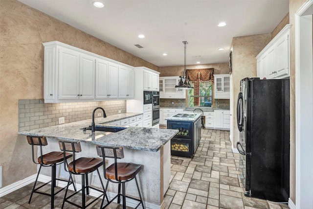 kitchen featuring sink, hanging light fixtures, kitchen peninsula, stainless steel appliances, and white cabinets