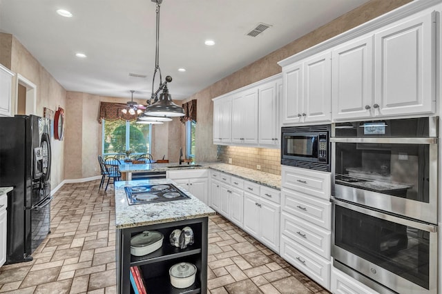 kitchen with white cabinetry, hanging light fixtures, a kitchen island, and black appliances