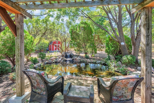 view of patio with a storage unit and a small pond