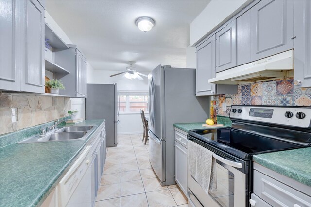 kitchen with decorative backsplash, sink, light tile patterned floors, and appliances with stainless steel finishes