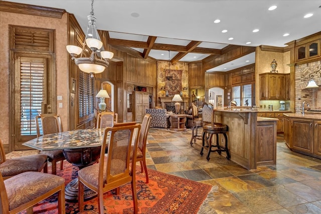 dining area with beamed ceiling, ornamental molding, coffered ceiling, and a notable chandelier