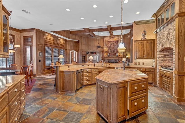 kitchen featuring kitchen peninsula, an island with sink, and hanging light fixtures