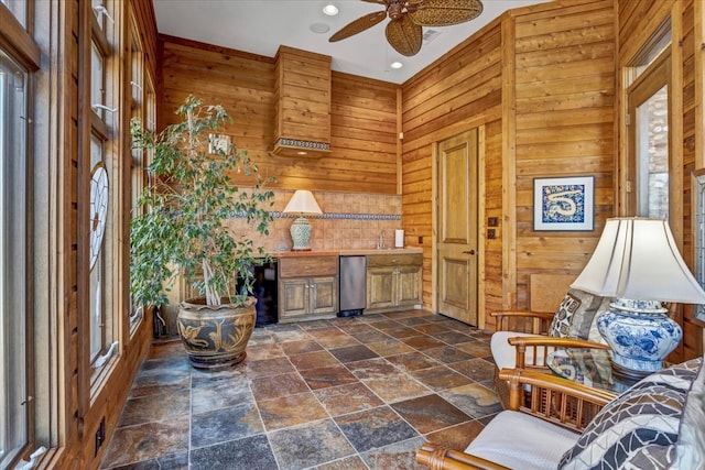 unfurnished room with plenty of natural light and wooden walls