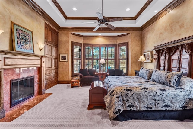 carpeted bedroom featuring a tray ceiling, ceiling fan, and crown molding