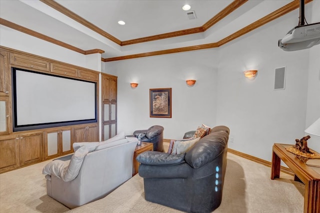 cinema with a raised ceiling, crown molding, and light carpet