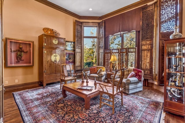 living area featuring dark hardwood / wood-style flooring, ornamental molding, and a high ceiling