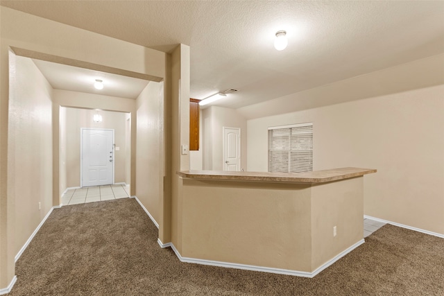 bar with a textured ceiling and light carpet