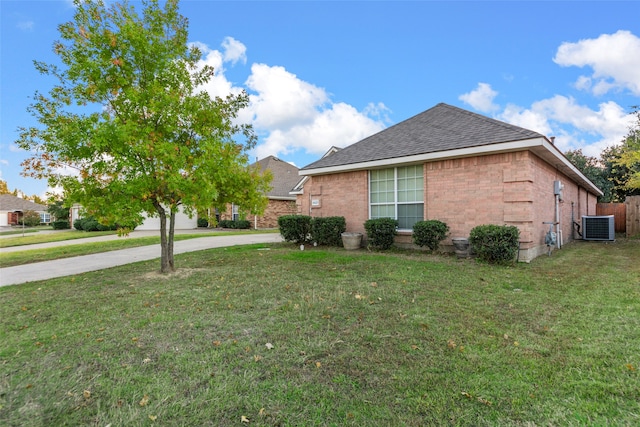 view of side of home featuring central AC and a yard