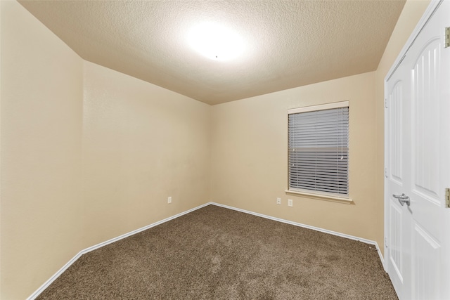 empty room with carpet flooring and a textured ceiling