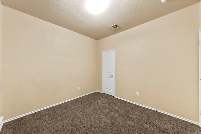 carpeted empty room featuring a textured ceiling