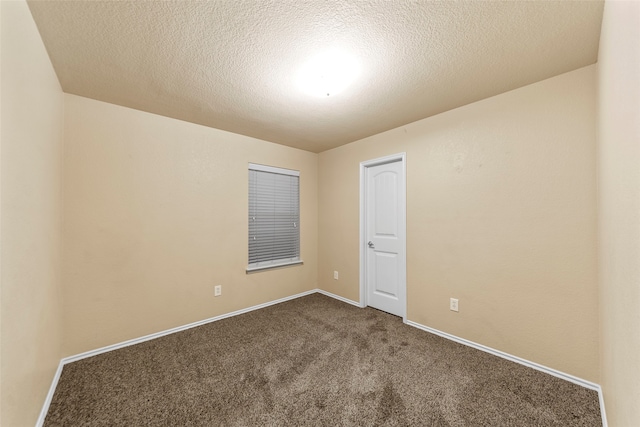 empty room featuring dark colored carpet and a textured ceiling