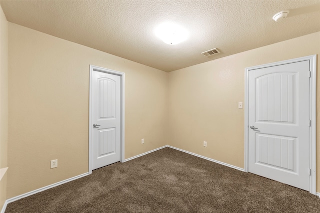 carpeted spare room with a textured ceiling