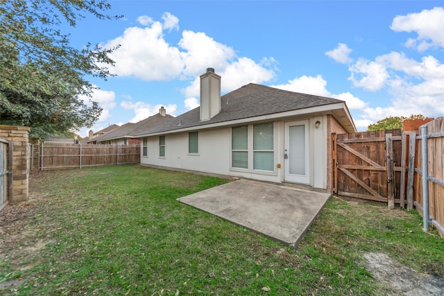 back of house with a yard and a patio