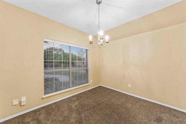 spare room with carpet flooring and a chandelier