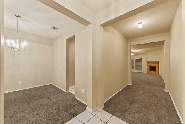 hallway with light colored carpet and a chandelier