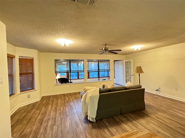 living room featuring wood-type flooring, a textured ceiling, and ceiling fan