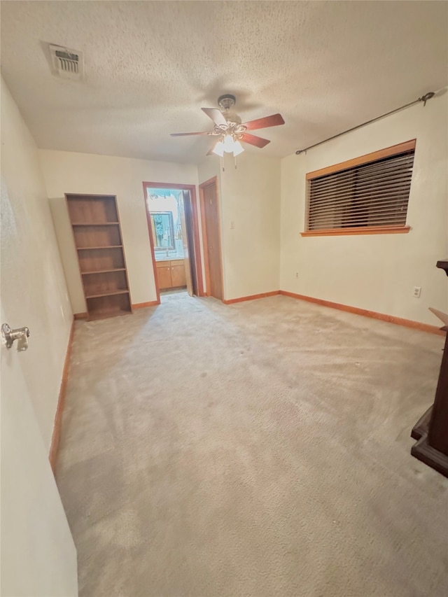 unfurnished bedroom with carpet flooring, ceiling fan, and a textured ceiling