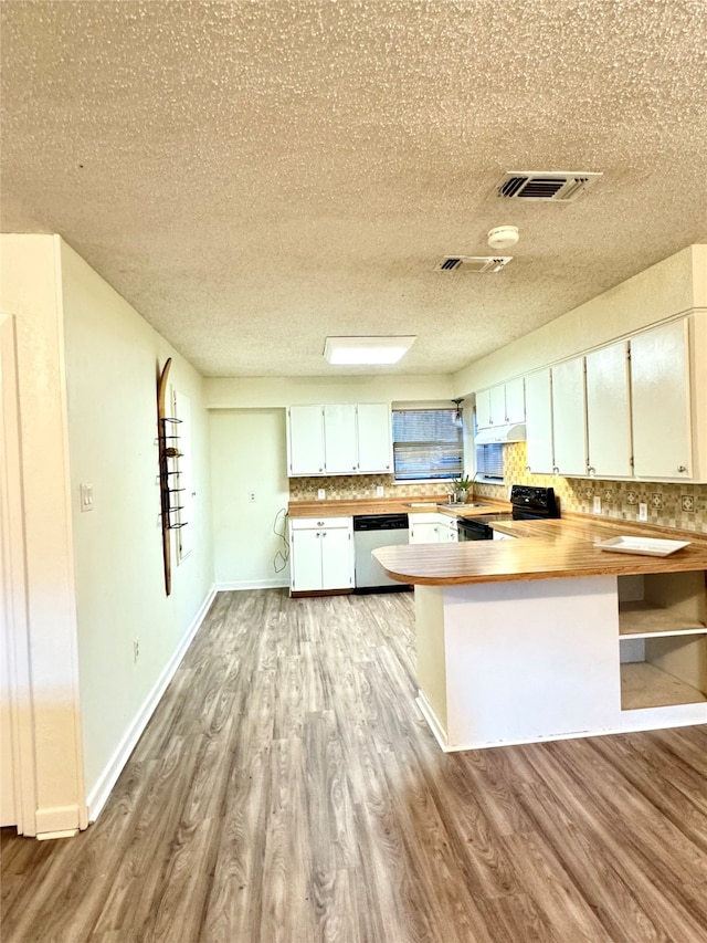 kitchen featuring kitchen peninsula, dishwasher, white cabinets, light hardwood / wood-style floors, and black range with electric stovetop