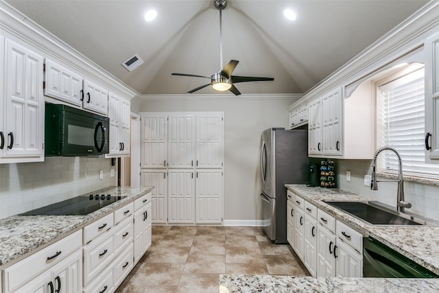 kitchen featuring black appliances, sink, vaulted ceiling, decorative backsplash, and white cabinetry