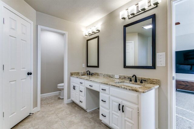 bathroom featuring tile patterned floors, vanity, and toilet