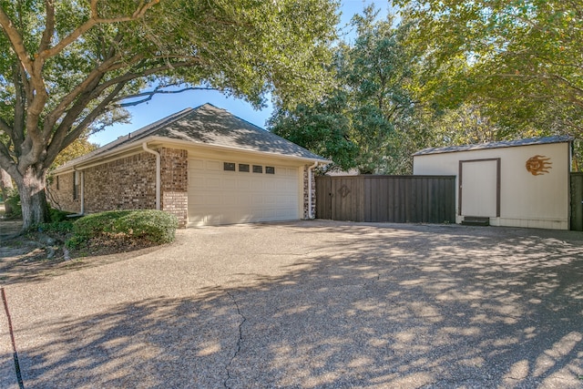 view of home's exterior featuring a garage and a storage shed