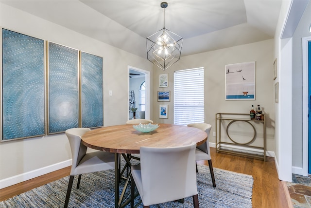 dining room with wood-type flooring and an inviting chandelier