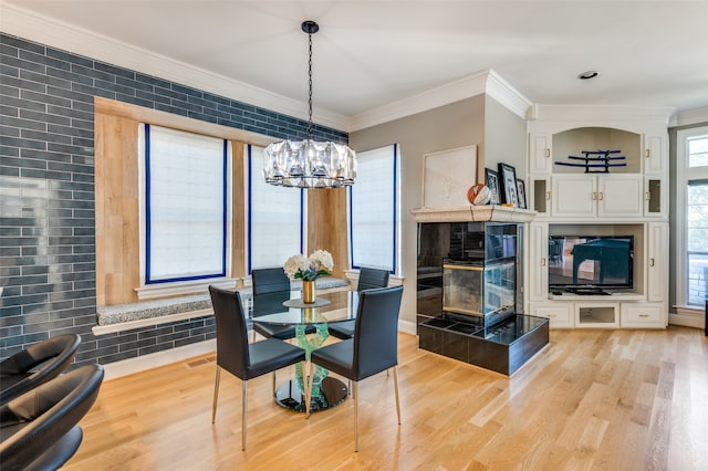 dining area featuring a chandelier, light hardwood / wood-style flooring, and ornamental molding