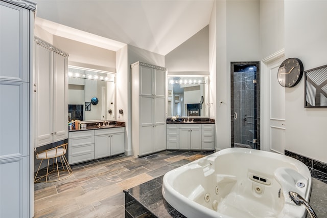 bathroom with plus walk in shower, vanity, and high vaulted ceiling