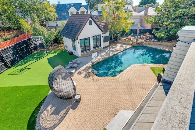 view of swimming pool featuring a lawn, an outbuilding, and a patio