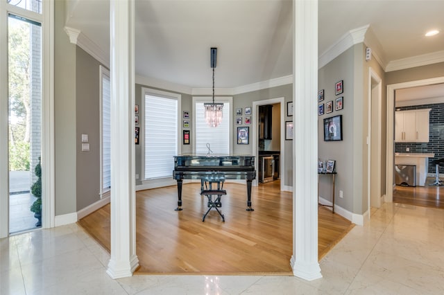 dining space with decorative columns, plenty of natural light, light hardwood / wood-style floors, and ornamental molding