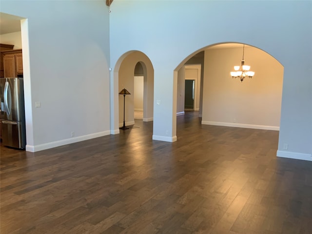 empty room with a chandelier and dark hardwood / wood-style floors