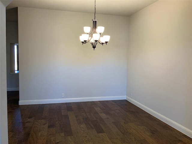 unfurnished room featuring dark hardwood / wood-style floors and a chandelier