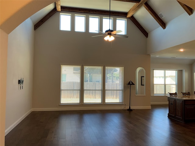 unfurnished living room featuring beamed ceiling, ceiling fan, dark wood-type flooring, and high vaulted ceiling