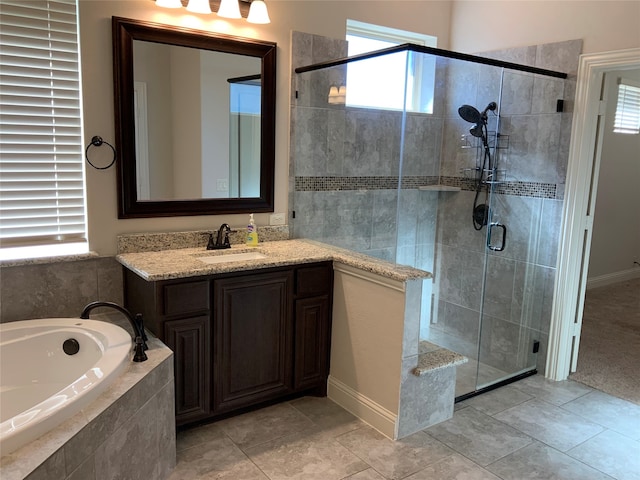 bathroom featuring tile patterned floors, vanity, a healthy amount of sunlight, and plus walk in shower