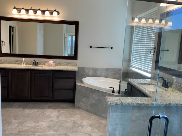 bathroom with vanity and tiled tub