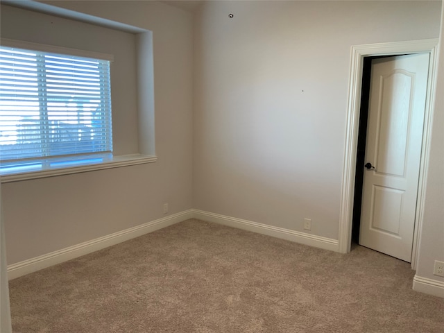 spare room featuring light colored carpet