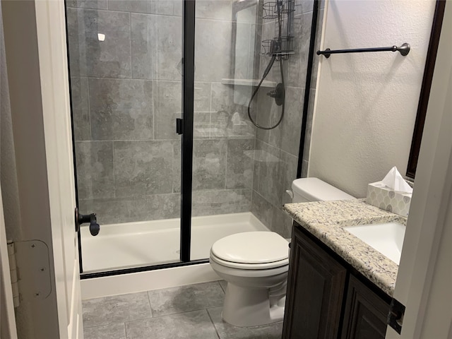 bathroom with walk in shower, tile patterned flooring, vanity, and toilet